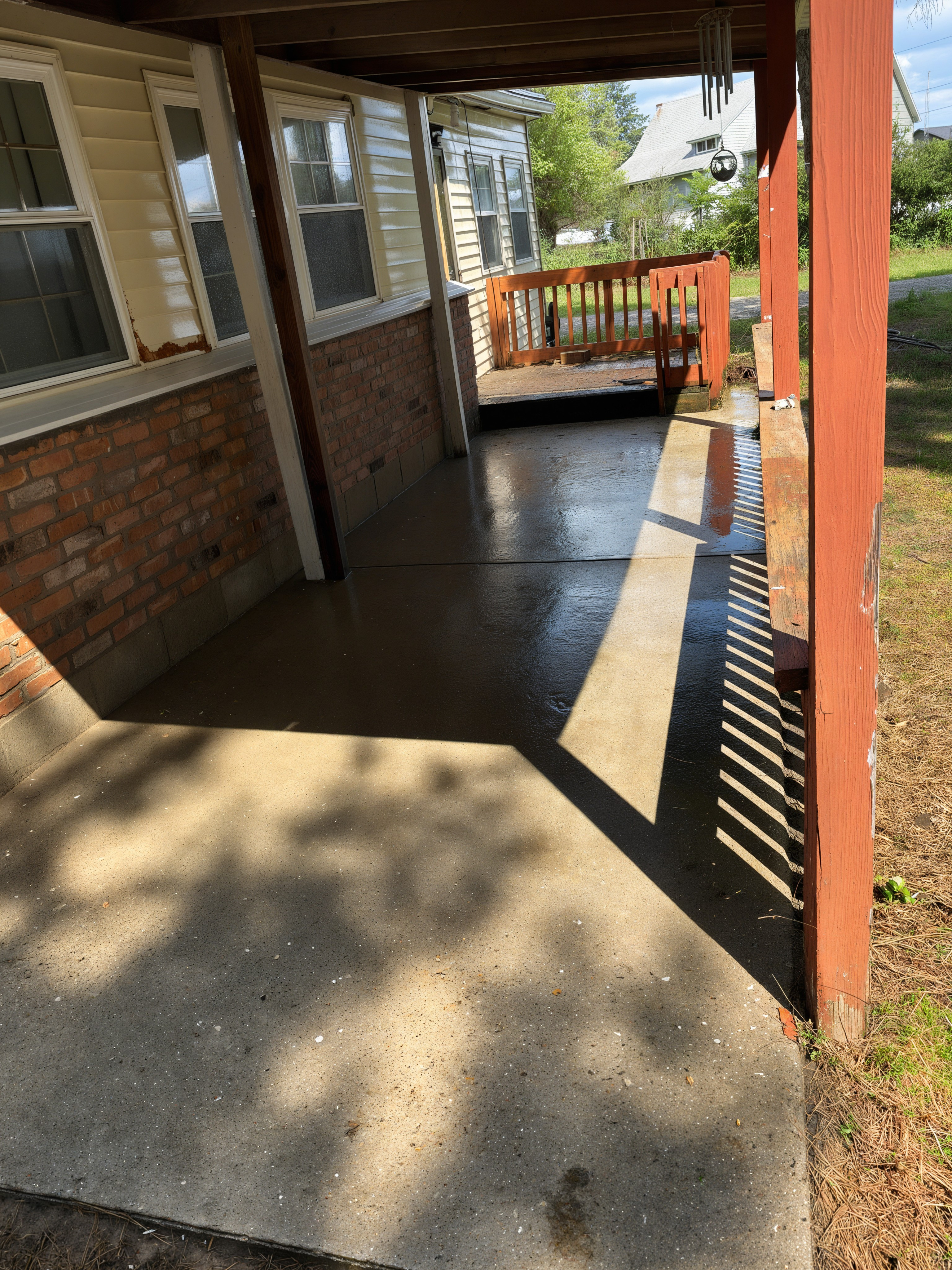 After: porch cleaned, brick house with red posts